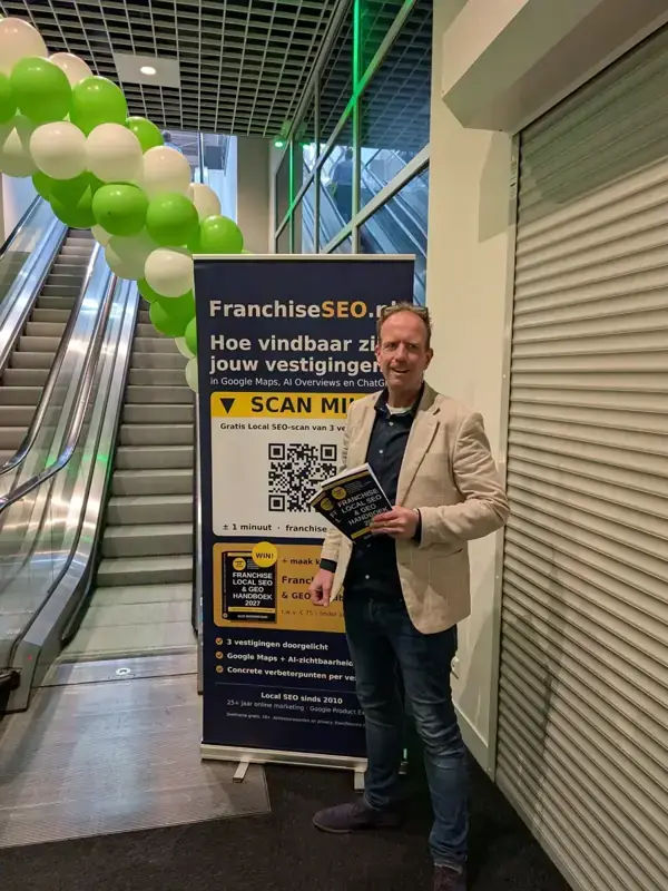 Gijs Bodenstaff met het Franchise Local SEO & GEO Handboek 2027 bij de FranchiseSEO.nl-banner op de Nationale Franchise Beurs in Gorinchem